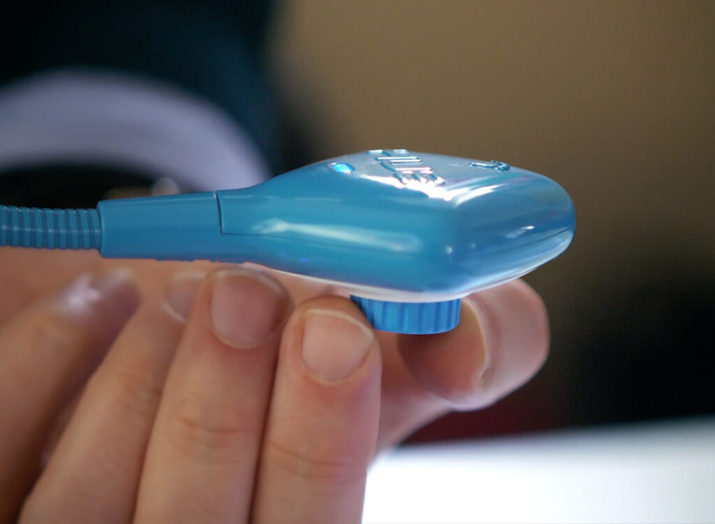 A close-up of the HUE HD Pro document camera showing a user turning its rubberized manual focus ring.