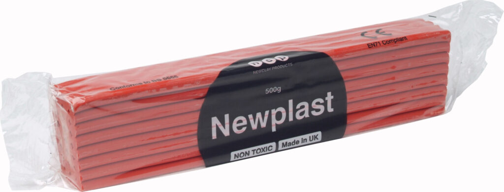 An original bar of red Newplast clay marked with the Newclay Products branding and conformity information