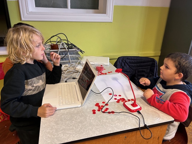Children in groups in a classroom. They are using the HUE HD Pro camera to animate their own movies through stop motion.